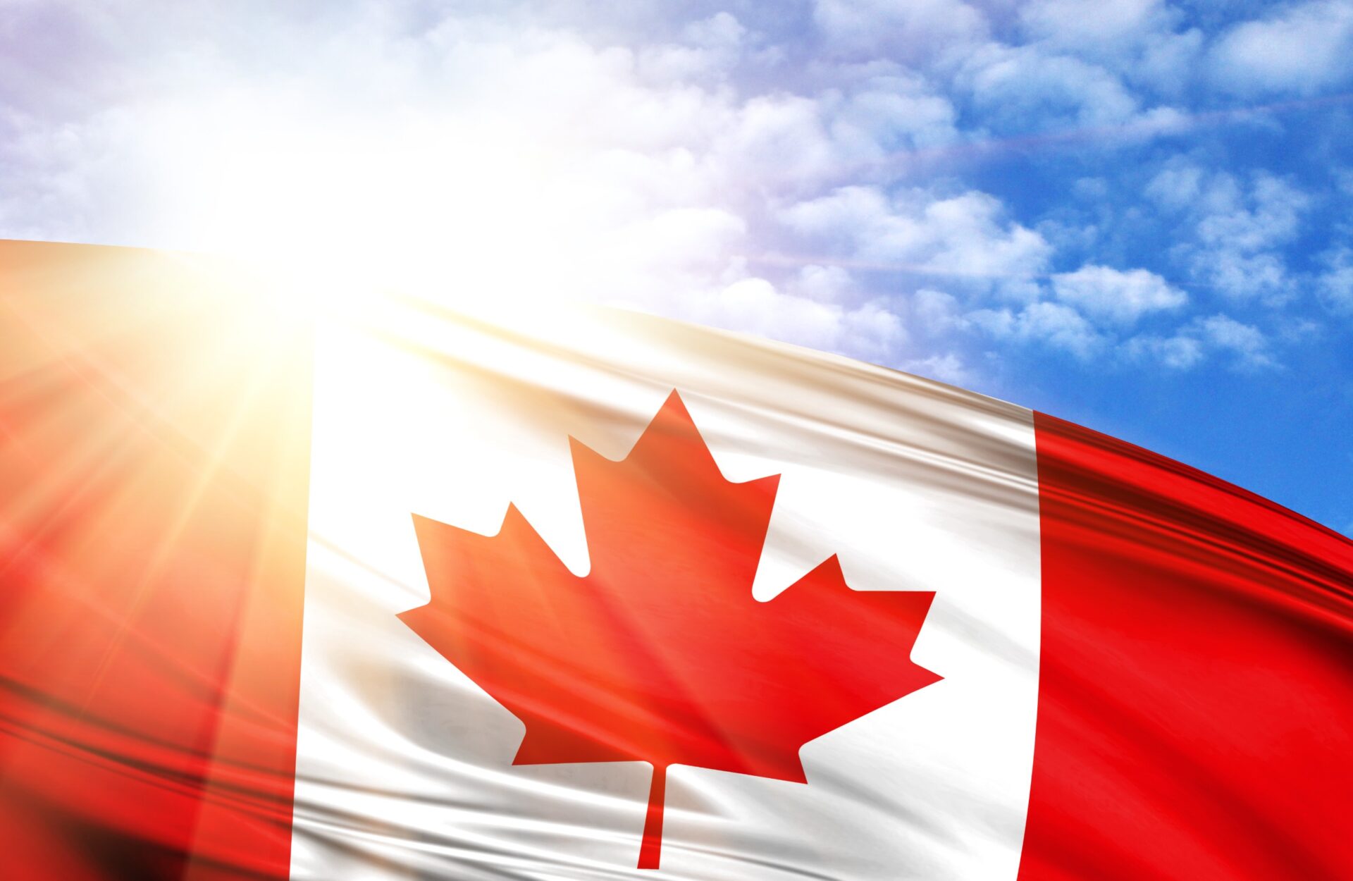 flag of Canada against the blue sky with sun rays. flag of Canada against the blue sky with sun rays.